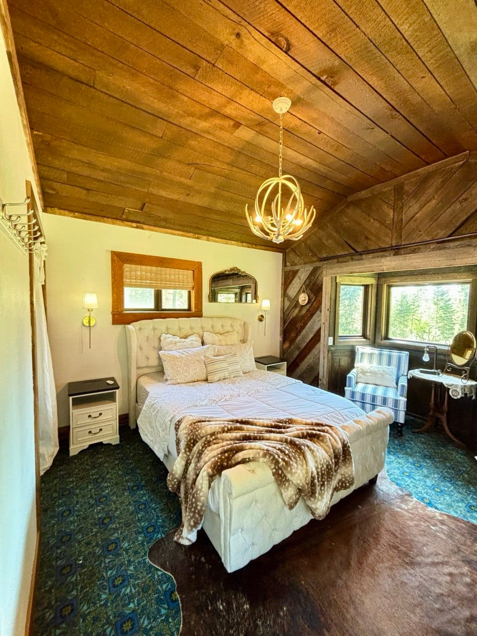 Bedroom with vaulted wood ceiling, queen bed, and chandelier
